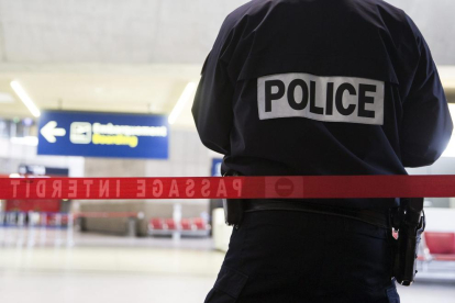 Un agente de policia vigila un aeropuerto de París.