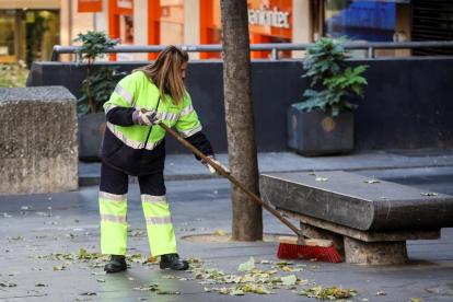 Una treballadora neteja el carrer.