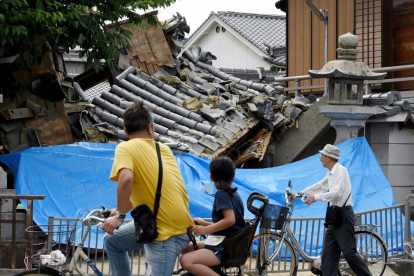 Veïns de la localitat de Takatsuki observen els danys del sisme.