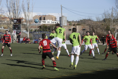 El jugador visitante Fabregat se eleva por encima del resto para despejar de cabeza, ante la presencia de Traguany y del local Jordi Martí.
