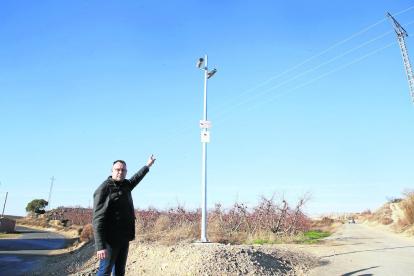 El alcalde de La Portella, Carles Català, muestra dos de las cámaras instaladas en los caminos del pueblo. 