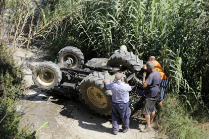 Vista del tractor volcado ayer en el camino de Vilanova de la Barca, en el municipio de Torrelameu. 