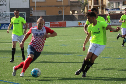 Adrià, con el balón controlado, encara a un jugador del Viladecans, con otros dos rivales atentos al balón.
