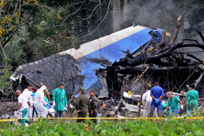 Policies i militars treballen entre les restes de l’avió.