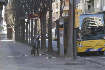 Una usuària de l’autobús baixa creuant el carril bici.