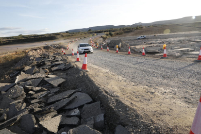 Un cotxe circulant per la rampa habilitada a la carretera de Cervià, al costat de fragments de la calçada.