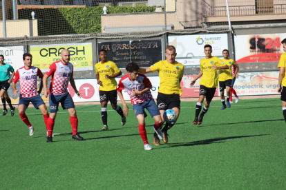 Un jugador del Balaguer i un altre del Lleida B lluiten per la possessió d’una pilota.
