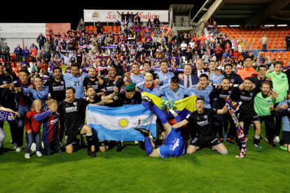 Jugadores y aficionados del Huesca desplazados a Lugo para animar al equipo celebran el ascenso.