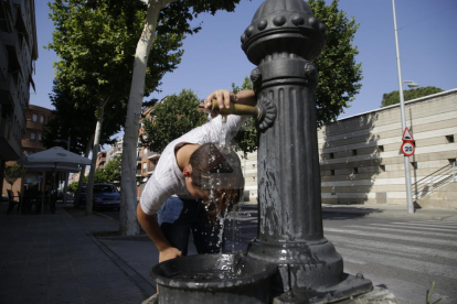 Un niño se refresca en una fuente en plena ola de calor en Lleida.