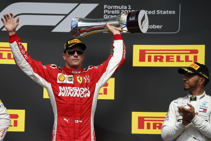 Hamilton aplaude a Kimi Raikkonen tras recoger el finlandés la copa de ganador en Austin.
