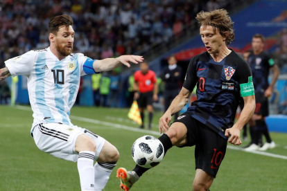 Leo Messi disputa el balón con Luka Modric, un duelo entre barcelonista y madridista trasladado al Mundial.