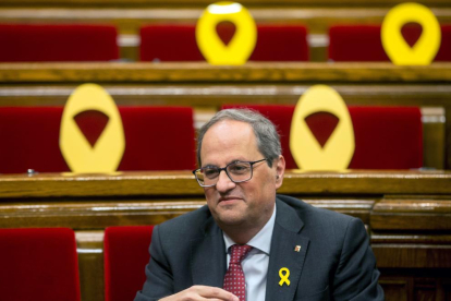 El president Torra en una imatge al Parlament envoltat d’escons amb llaços grocs.