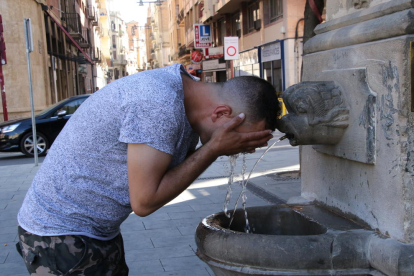 Un jove es refrescava ahir en una font de Lleida, on es va arribar als 35,2 graus.