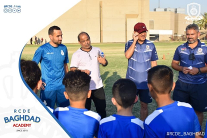 Xavier Codina, primero por la izquierda, junto a entrenadores de la academia que tiene el Espanyol en Baghdad dirigiéndose a unos niños.