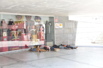 Un grup d’immigrants dormint a la part ombrejada del centre cívic de plaça l’Ereta, ahir.