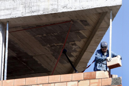 Imatge d’un treballador en la construcció d’un bloc d’habitatges.