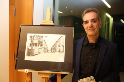 El artista Óscar Lalana, junto a uno de sus dibujos de la Almacelles de un siglo atrás.