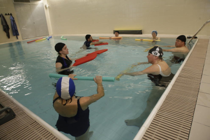 A l’esquerra, pacients fent ahir exercicis de rehabilitació i, a la dreta, una grua que permetrà ajudar usuaris a entrar a la piscina.