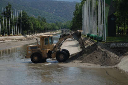 Una màquina excavadora retira el llot acumulat al canal d’aigües tranquil·les.
