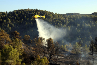 Un helicóptero descargando agua sobre el incendio. 