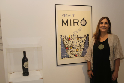 L’artista guanyadora, Núria Rossell, ahir al costat de la seua obra i la botella de Vermuts Miró.