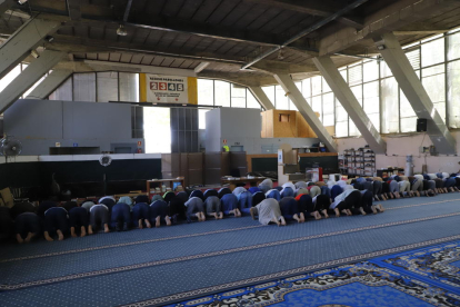 A la izquierda, imagen del solar que acogerá la mezquita en septiembre y octubre y, a la derecha, musulmanes rezando ayer en el Palau de Vidre.