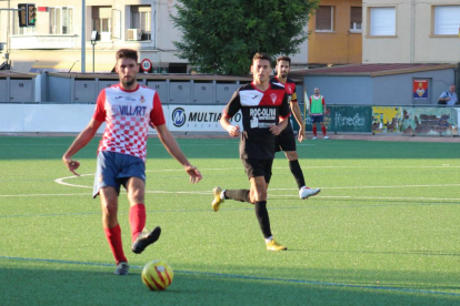 Un jugador del Balaguer passa la bimba davant la pressió dels rivals.