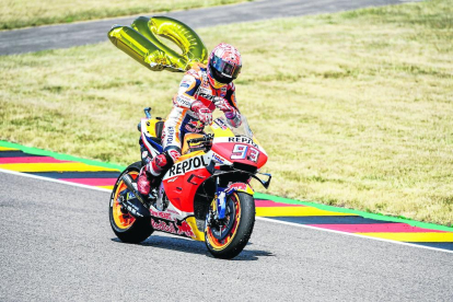 Àlex levanta la rueda delantera de su moto tras ganar la carrera.