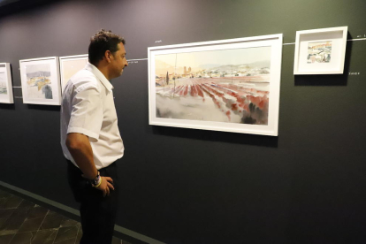 Un dels visitants a l’exposició contempla una aquarel·la a la Sala Montsuar de l’IEI.
