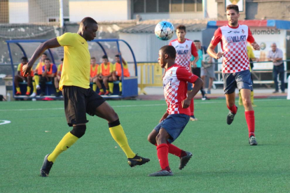 Buba Mballo, jugador del Balaguer, intenta controlar el balón ante la potencia física de Cheikh Saad, del EFAC Almacelles.