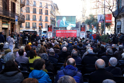 Centenars de persones segueixen la declaració de Jordi Cuixart al Suprem amb una pantalla gegant des de davant de la seu d'Òmnium a Barcelona. Imatge del 26 de febrer del 2019.