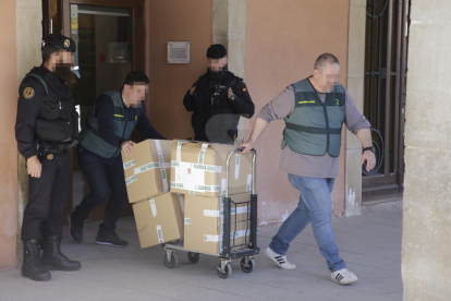 Agentes de la Guardia Civil se llevan del ayuntamiento de Almacelles cajas con documentos.