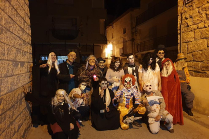 Participantes en el pasaje del terror celebrado la noche del jueves en La Granja d’Escap. A la derecha, una de las casas de la calle Tort convertida en una sangrienta mazmorra. 