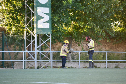 Dos bombers, durant els treballs per despenjar la pancarta publicitària que es va desprendre.