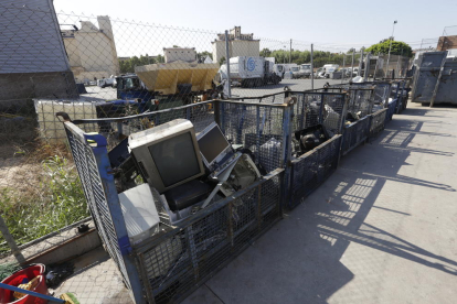 Un trabajador de la ‘deixalleria’ de Pardinyes, junto a un contenedor con aparatos electrónicos.