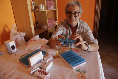 Aurelio con los medicamentos que toma cada día y junto a los de su mujer.