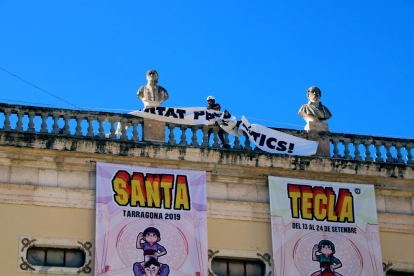 Un operario retiró ayer la pancarta por los presos del ayuntamiento de Tarragona por orden de la JEC.