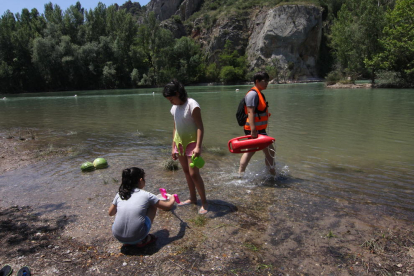 Un grupo practicando deportes acuáticos en Gimenells y, en la imagen derecha, la vigilante de la zona de baño de Camarasa, que empezó a trabajar ayer.