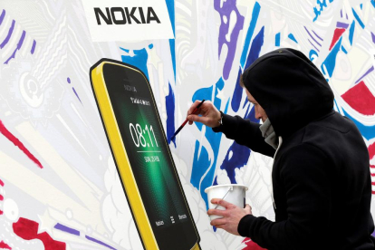 Un artista pinta un cartell del Nokia 8110.