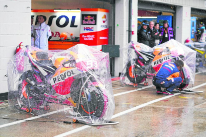 Les motos de Marc Màrquez i Dani Pedrosa, protegides de la pluja que va caure sobre Silverstone.