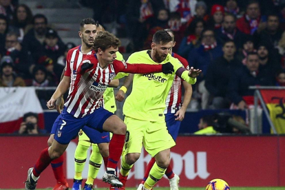 Leo Messi intenta avanzar con el balón ante la presión del francés Griezmann, en un partido en el que ninguno de los dos brilló especialmente.