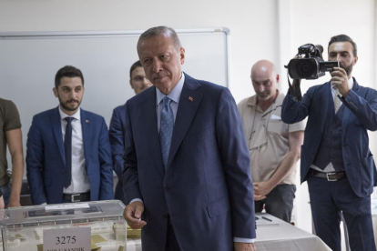 El presidente turco, Recep Tayyip Erdogan introduce su voto en la urna para las elecciones.