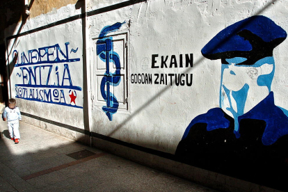 Mural que representa un encaputxat al costat de l’anagrama d’ETA.