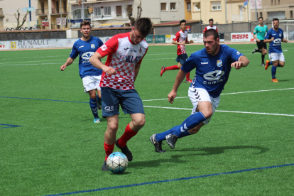 Genís porta una pilota davant l’oposició de dos jugadors rivals.