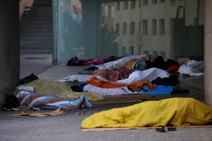 Temporeros durmiendo el lunes ante el centro cívico de l’Ereta.