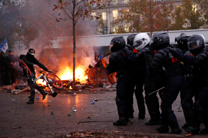 La policía antidisturbios francesa se enfrenta en París a manifestantes en una protesta contra los planes de reforma de las pensiones. 