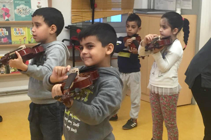 Un grup d’alumnes del taller tocant el violí.