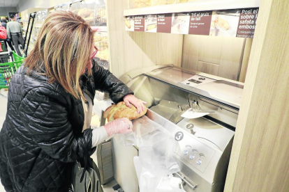 Una clienta corta el pan a su gusto en el Mercadona erigido en la zona del antiguo Nou Forn de Lleida.