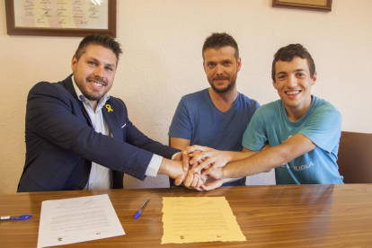 L’alcalde i dos membres de l’associació, al firmar el conveni.