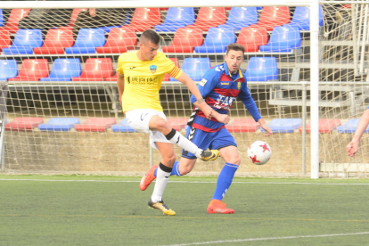 El capitán del Lleida, Marc Nierga, remata ante la presencia de un jugador del equipo gerundense.